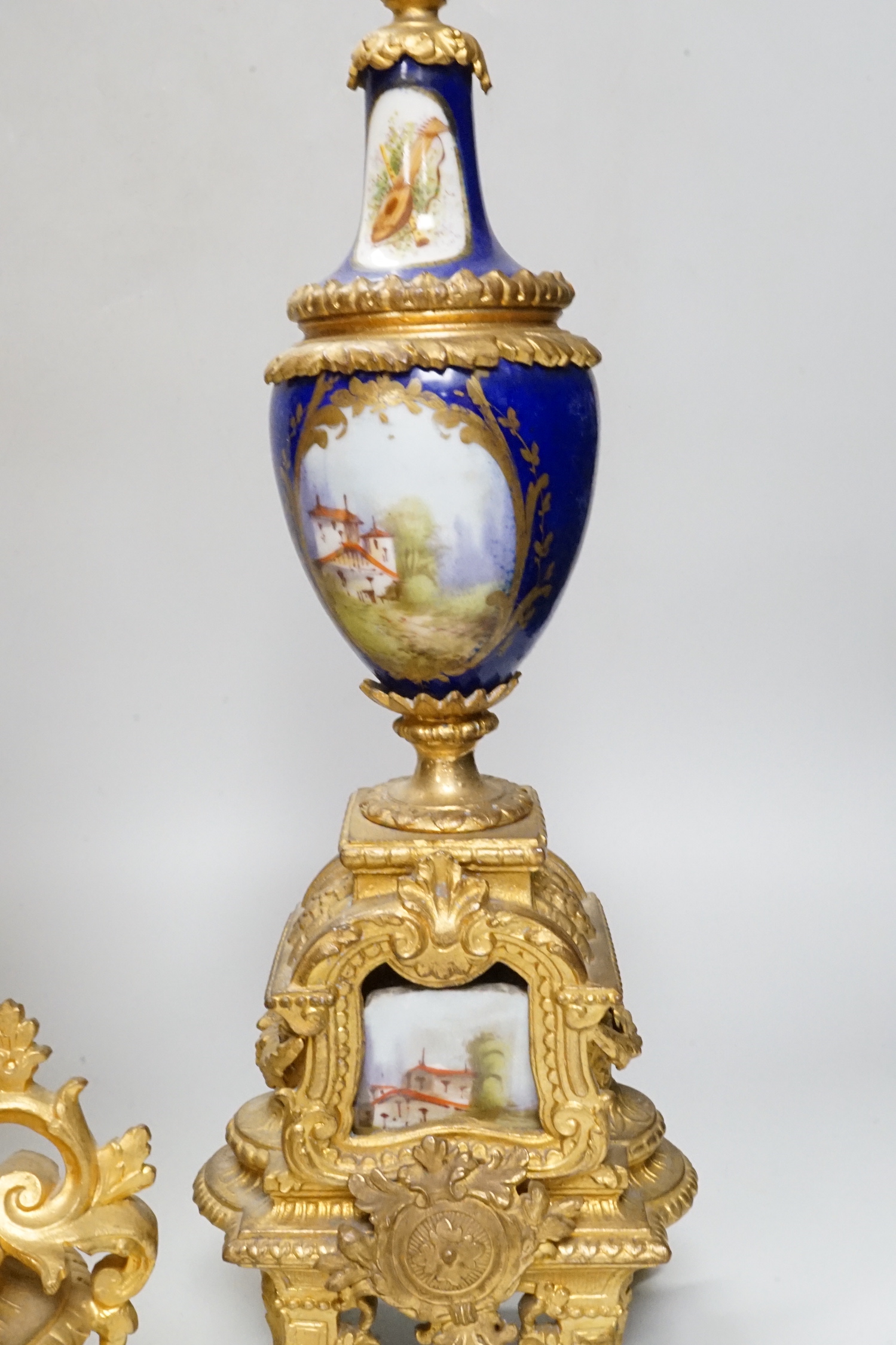 An early 20th century French gilt metal and porcelain set clock garniture, 42cm